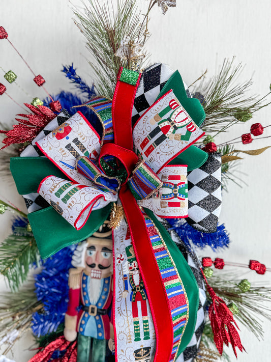 🎄 Nutcracker Teardrop Swag : A statement piece of Christmas elegance — this handcrafted Nutcracker swag blends classic charm with rich emerald velvet, harlequin ribbons, and glittering holiday details.
