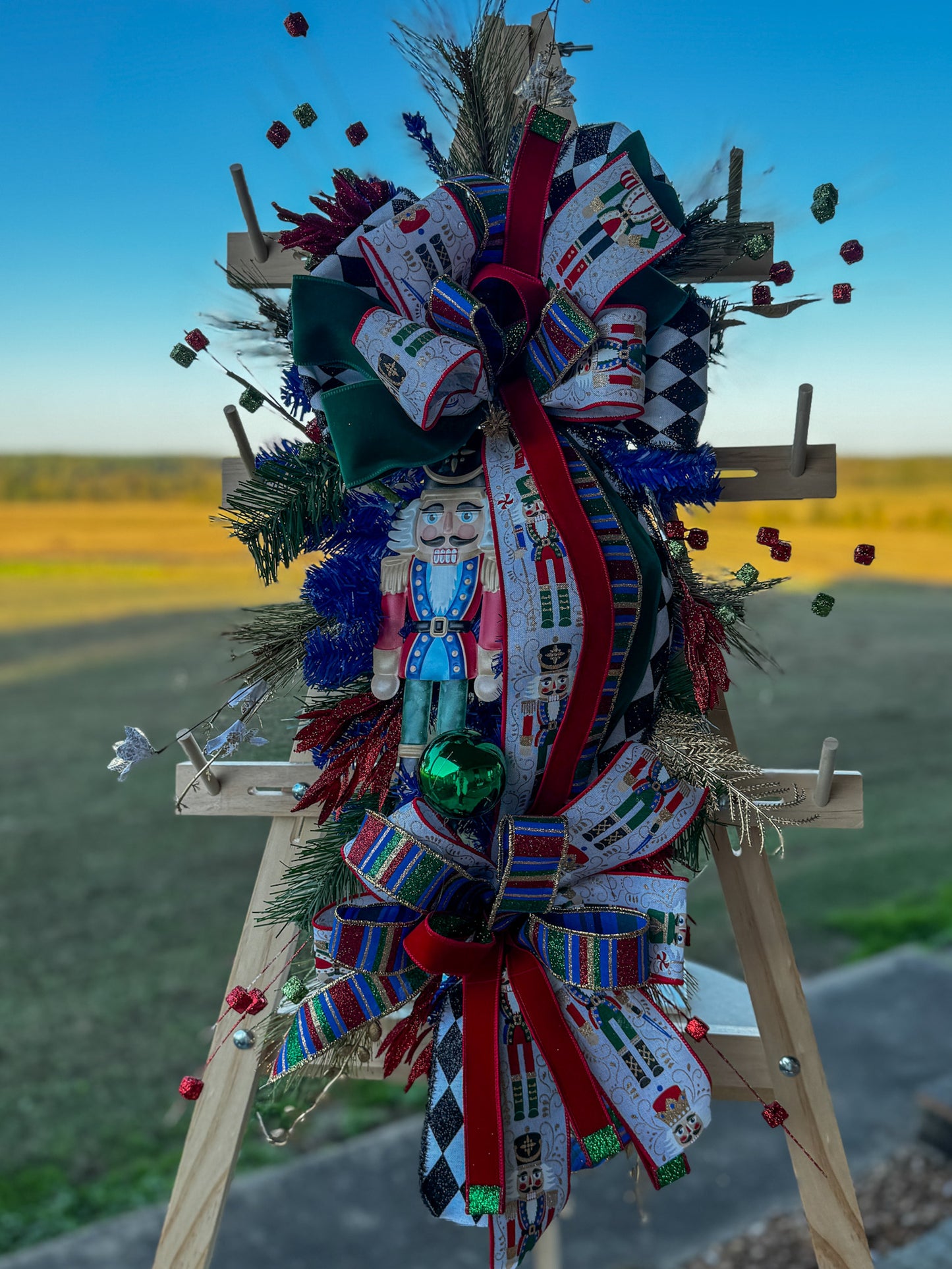 🎄 Nutcracker Teardrop Swag : A statement piece of Christmas elegance — this handcrafted Nutcracker swag blends classic charm with rich emerald velvet, harlequin ribbons, and glittering holiday details.