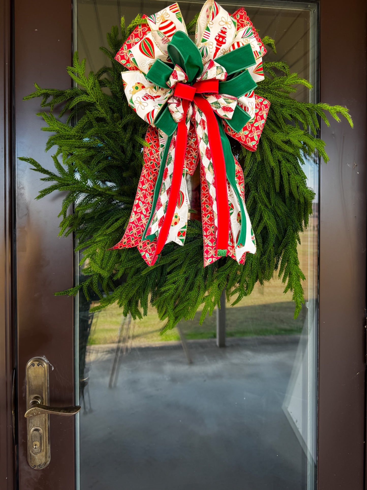 Christmas wreath with a large decorative bow on a glass door