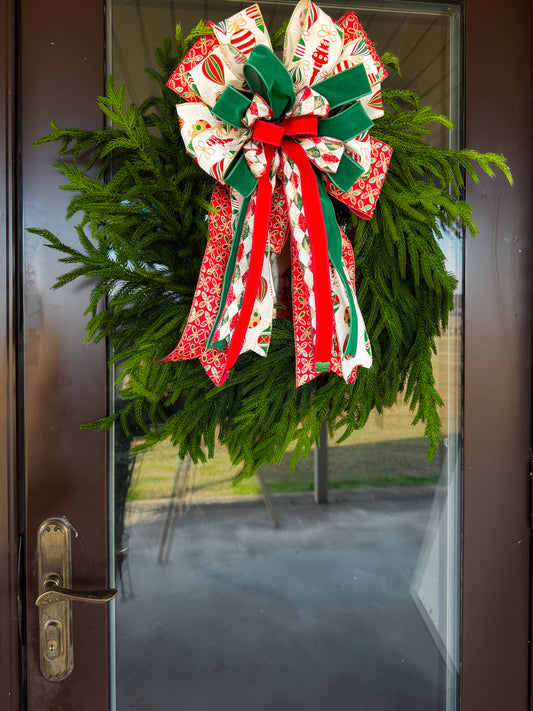 Christmas wreath with a large decorative bow on a glass door